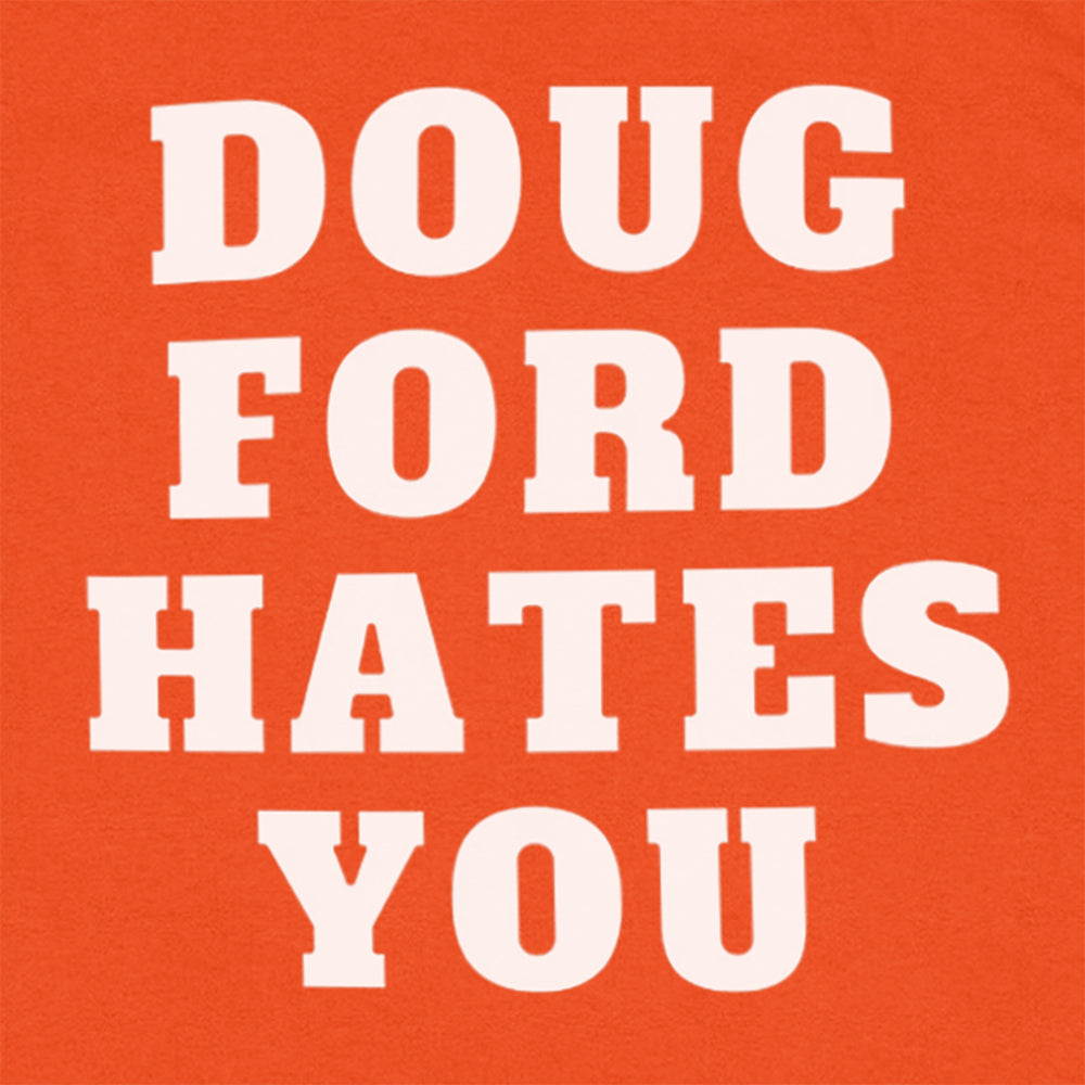 Close up view of the original Doug Ford Hates You t-shirt. Bold white letters screen printed on an orange shirt. Colorful graffiti stickers make up the background.