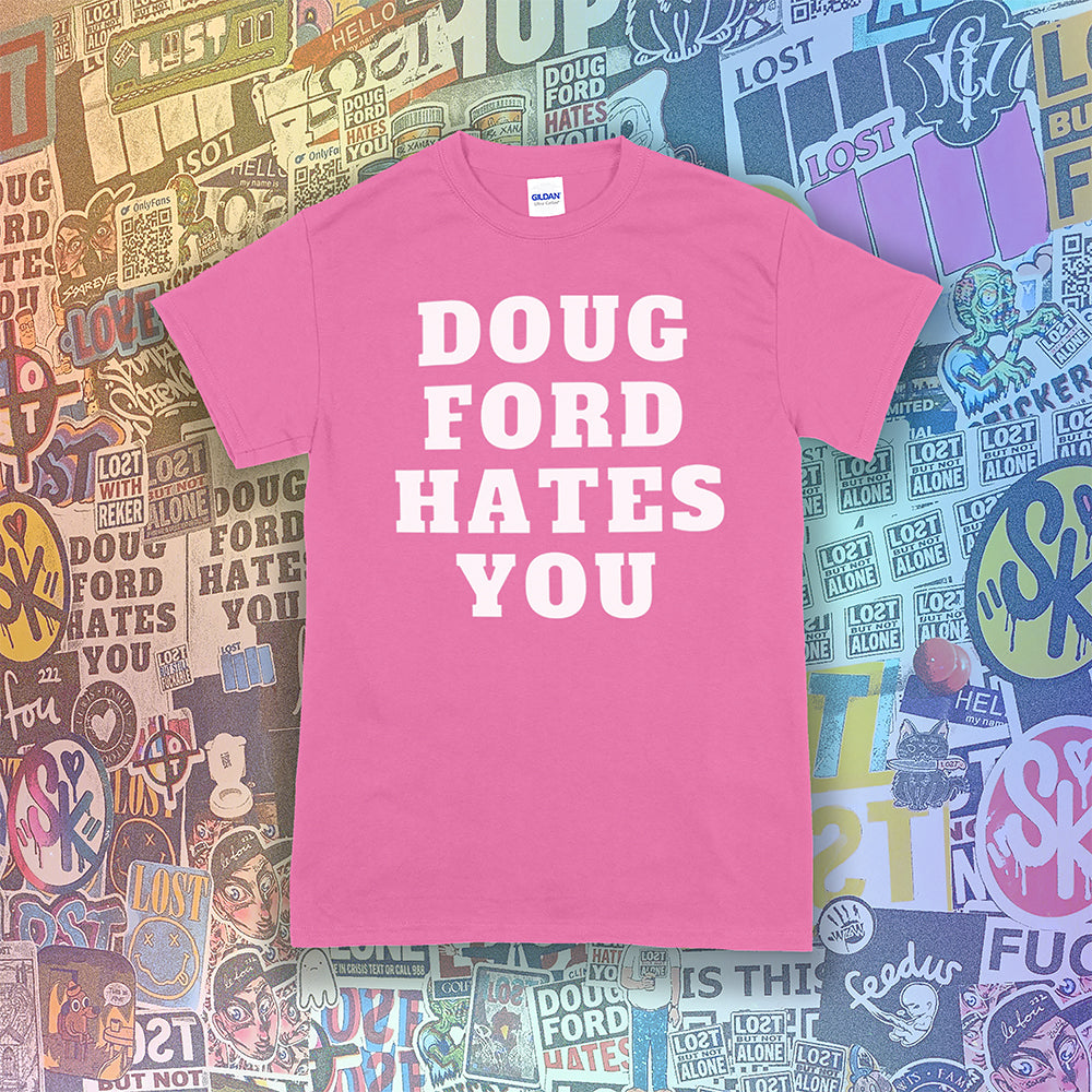 The original Doug Ford Hates You t-shirt. Bold white letters screen printed on a bright pink shirt. Colorful graffiti stickers make up the background.