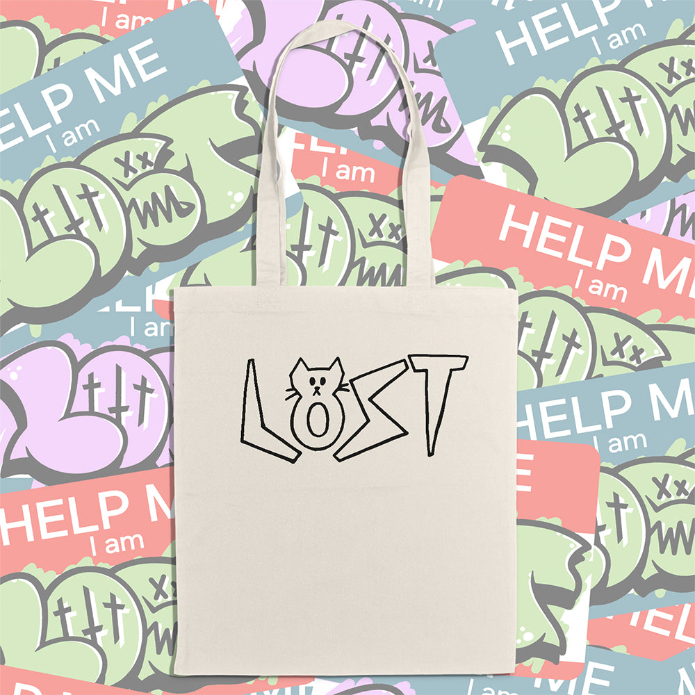 Cat shaped spell out the word LOST across a large tote bag. Hand drawn my my daughter Charlotte and printed in black on natural canvas tote bags. An assortment of colorful graffiti stickers makes up the display background.
