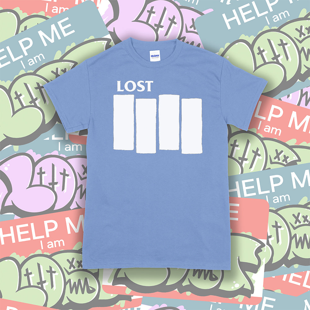 The Lost Flag t-shirt. The iconic bold logo is screen printed in white ink on a Carolina blue cotton shirt. A collection of colorful graffiti stickers make up the background.