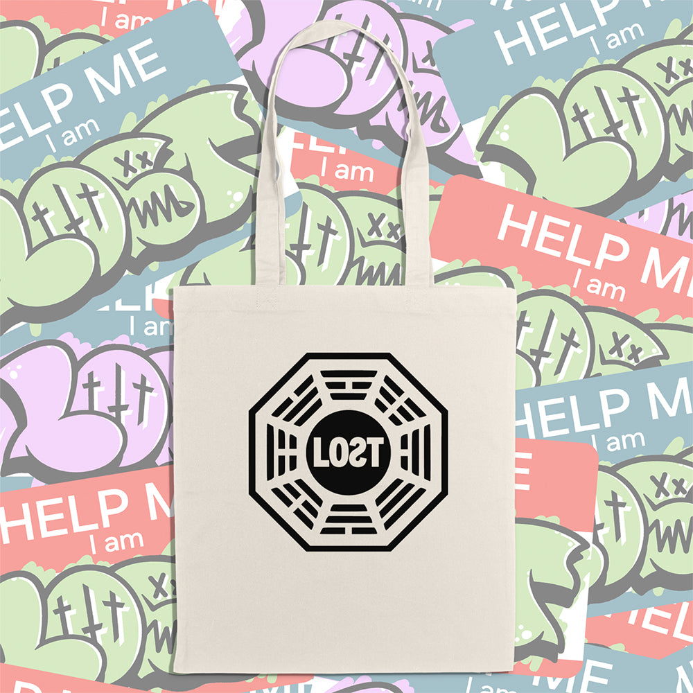 The bold and iconic octagon logo with the word LOST printed in bold black ink and displayed on a large natural canvas tote bag. A wall of colorful graffiti stickers featuring artists from around the world creates a vibrant background for the tote bag on display.