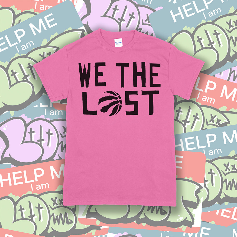 We The Lost t-shirt. Bold black lettering screen printed on a bright pink shirt. Assorted colorful graffiti stickers make up the background.