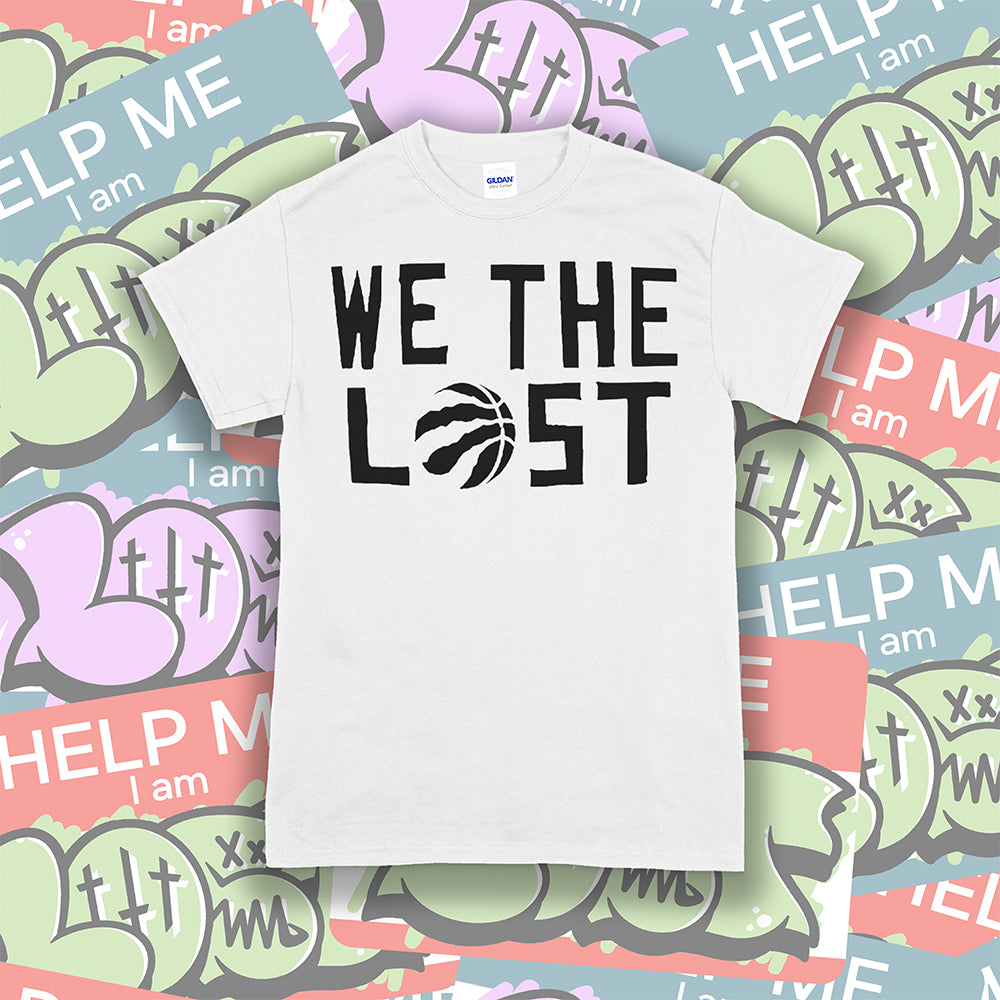 We The Lost t-shirt. Bold black lettering screen printed on a bright white shirt. Assorted colorful graffiti stickers make up the background.